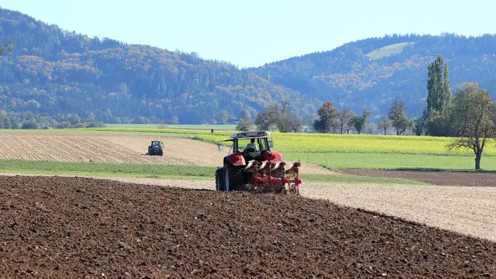 FJDynamics AT2 tractor autosteer kit in operation, spreading seeds precisely on farmland.